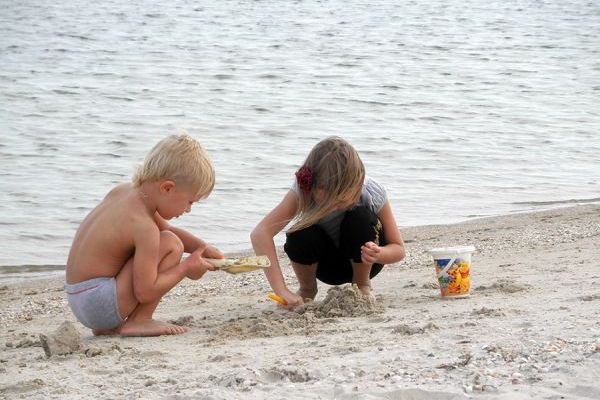 Дети играют в песке на пляже