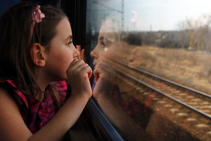 Девочка смотрит в окно поезда